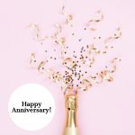 champagne_bottle_with_confetti_stars_and_party_streamers_on_pink_picture_id1057557292